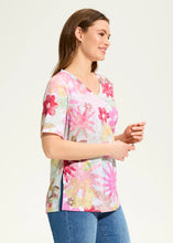 Load image into Gallery viewer, Our Aria Starburst top features a lively floral pattern that bursts with vibrant colors and intricate designs. This eye-catching print adds a cheerful and dynamic touch to the top, making it perfect for brightening up your wardrobe. The A-line silhouette creates a flowing and flattering style. Whether you decide to style it on its own or under a favorite denim jacket, this top is perfect for the warm weather season.