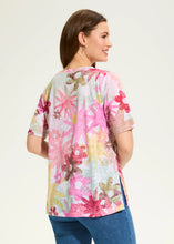 Load image into Gallery viewer, Our Aria Starburst top features a lively floral pattern that bursts with vibrant colors and intricate designs. This eye-catching print adds a cheerful and dynamic touch to the top, making it perfect for brightening up your wardrobe. The A-line silhouette creates a flowing and flattering style. Whether you decide to style it on its own or under a favorite denim jacket, this top is perfect for the warm weather season.
