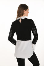 Load image into Gallery viewer, Woman wearing a black and white contrast tunic blouse with jewel embellishments and black pants against a white background.