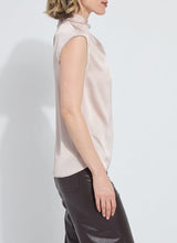 Load image into Gallery viewer, Woman wearing a light pink sleeveless blouse and brown leather pants against a white background.