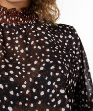 Load image into Gallery viewer, This brown, smocked long sleeve blouse, featuring swirling circles known as "Animal Steps," is a fashionable piece that can be dressed up or down depending on the occasion. Its unique design offers a chic and stylish look. Color-Brown, black, brown. Button back closure. Smocked neck and sleeves. Slightly sheer. Suggest wearing a black bra or black cami underneath.