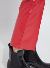 Load image into Gallery viewer, Close-up of hem on red faux leather pants and black boots against a white background.
