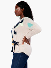 Load image into Gallery viewer, This sleek design combines patterned and natural elements to create an attractive, understated look. The intarsia pattern is seasonally versatile, while the functional side tie adds a personalized touch. Crafted with eco-friendly materials, this pullover is designed to be part of a sustainable wardrobe. Color-Indigo multi- Navy, yellow gold, pinks, turquoise, white and sand. Pullover sweater. Intarsia knit. Midweight. Easy fit. Round neck. Tie front. Sits at hip.