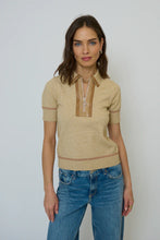 Load image into Gallery viewer, Woman wearing a short sleeve brown polo sweater with contrasting faux leather and blue jeans against a neural background.