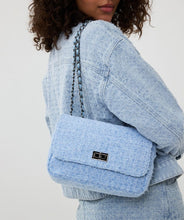 Load image into Gallery viewer, The Esqualo Denim Bag is a stylish and versatile accessory. It features a distressed denim design with black steel detailing, a twist-lock closure, and a zippered pocket on the back. Perfect for adding a chic touch to your outfit.