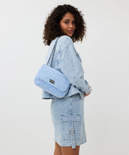 Load image into Gallery viewer, The Esqualo Denim Bag is a stylish and versatile accessory. It features a distressed denim design with black steel detailing, a twist-lock closure, and a zippered pocket on the back. Perfect for adding a chic touch to your outfit.