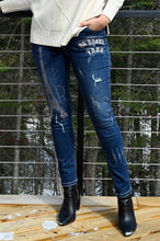 Load image into Gallery viewer, The Frank Lyman jean, also known as the "Brooklyn Be Brave & Free Sparkle Jean," is a dazzling addition to any wardrobe. These jeans feature sparkling details with phrases like "Be Brave, Be Free" shining on one side, and the Eiffel Tower along with the word "Paris" on both sides. Made from a blend of cotton, polyester, rayon, and elastane, they offer stretchable comfort and a stylish edge.