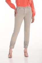 Load image into Gallery viewer, Our Cassie jean is a stylish and comfortable choice for any wardrobe. These woven pants feature a 5-pocket jean cut with intricate cut-out and sparkling embellishment details at the ankle, adding a unique touch to the classic design. Made from a blend of 98% cotton and 2% spandex, they offer a soft, stretchy feel that ensures all-day comfort. Perfect for both casual and dressy occasions, these pants are a versatile addition to your collection.