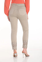 Load image into Gallery viewer, Our Cassie jean is a stylish and comfortable choice for any wardrobe. These woven pants feature a 5-pocket jean cut with intricate cut-out and sparkling embellishment details at the ankle, adding a unique touch to the classic design. Made from a blend of 98% cotton and 2% spandex, they offer a soft, stretchy feel that ensures all-day comfort. Perfect for both casual and dressy occasions, these pants are a versatile addition to your collection.