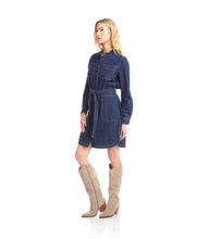 Load image into Gallery viewer, Woman wearing a belted blue denim dress and tall tan suede boots against a white background.