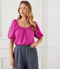 Load image into Gallery viewer, Add a pop of vibrant color to your wardrobe with the Karen Kane Becca Berry Pleat Sleeve Top. Featuring pleated tiers on the sleeves, a shirred neckline, and a flattering shirttail hem, this peasant-style top offers a charmingly feminine aesthetic. Crafted from 100% polyester heavy moss crepe, it’s lightweight and perfect for both casual and dressy occasions. Designed for comfort and style, this top is a versatile must-have for any season.