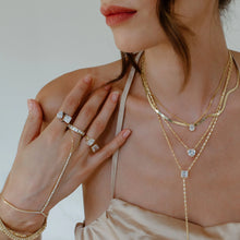 Load image into Gallery viewer, When you wear this stunning adjustable cubic zirconia ring, you will receive compliments. The one size fits all ring has one pear shaped cz and one square cut cz with a gold base. The best of both worlds! Color - Gold and clear. One size and adjustable. One pear shape cz and one square shape cz. 14 kt gold plate over brass.