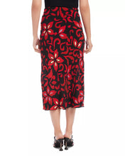 Load image into Gallery viewer, This stunning skirt boasts a vibrant red and black floral print that is guaranteed to flatter any figure. It can be styled with tall boots or heels and pairs beautifully with a black top or our coordinating pieces.