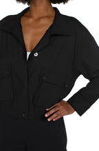 Load image into Gallery viewer, The Brylee utility jacket from Liverpool Los Angeles features a cropped design and cinched hem, perfect for adding a touch of edginess to any outfit. Made with a textured stretch woven fabric, this jacket offers both style and comfort. Stay effortlessly stylish with this versatile piece. Color- Black. Collared. Hidden button placket with zip front closure. Two front flap pockets with double button closure. Button tab at arm to roll sleeves. Cinch waist. Cropped.