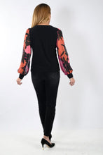 Load image into Gallery viewer, This Frank Lyman garment features a semi-sheer sleeve design in a bold magenta hue, adorned with an intricate floral pattern. Tailored with a stretchy fabric to provide a relaxed fit, the McKenna top pairs perfectly with jeans or trousers. Pair with our Bettany Black and Magenta Painted Foral Denim Jean - Frank Lyman 233886U for a perfect look. Color - Magenta, bright coral, pink and black. Billowy sleeves. Semi sheer sleeves. No pockets. No zipper.