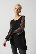 Load image into Gallery viewer, This luxurious tunic is crafted from a silky knit fabric, with mesh puff sleeves for a touch of drama. The asymmetrical design is flattering and feminine, while the beading detail adds a touch of glamour. Color - Black. Silky knit with mesh. Beading on sleeves. Boat neckline. Puff sleeves. Asymmetrical hem. Unlined.