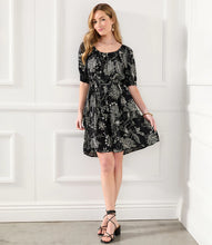 Load image into Gallery viewer, A charming scarf print puts a bohemian focus on this summer-ready dress. This statement-making dress features peasant sleeves, a tiered hem and flattering cinched waist and matching belt. Colors- Black and white. Short puff sleeve. Side pockets. Self-tie belt. Tiered hem. Cinched waist.
