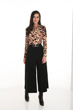 Load image into Gallery viewer, Woman wearing a leopard print top, black wide-leg pants and black boots against a white background.