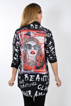 Load image into Gallery viewer, This sleek button-down tunic top dazzles with its bold white lettering on a black backdrop for a classic and eye-catching look. The back is sure to turn heads with its striking face and rhinestone glasses silhouette, creating a stylish look that exudes confidence and sophistication. Color- Black, white, red, orange, blue/gray, tan. Button-down. Tunic length.