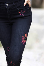 Load image into Gallery viewer, These black straight leg jeans crafted from exceptional denim feature eye-catching hand-painted motifs of bright magenta flowers, which are further accented with sequins and rhinestones for a dazzling finish. Make a bold style statement and stand out from the crowd in these extraordinary jeans. Color- Black and magenta. Slim leg design. Painted floral designs with sequin and rhinestones. Floral designs on front side only. Five functional pockets. Zipper and button closure.