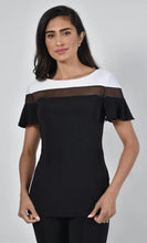 Load image into Gallery viewer, Expertly designed with timeless black and white contrast colors our Brenlynn top by Frank Lyman seamlessly transitions from day to evening. The unique ruffle short sleeves, sheer black panel, and contrasting colors add a dynamic touch to this versatile piece.