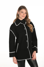 Load image into Gallery viewer, Woman wearing a black jacket with white trim and black leggings against a white background.