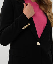 Load image into Gallery viewer, Woman wearing a black blazer with gold buttons over a pink shirt against a white background.