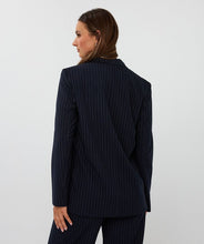Load image into Gallery viewer, Woman wearing a navy pinstripe blazer and pants against a white background.