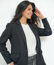 Load image into Gallery viewer, Make a stylish and confident statement with our EsQualo blazer. This timeless black blazer features exquisite beaded detailing on both sleeves, adding a touch of elegance to any outfit. This must-have piece belongs in every fashion-savvy closet and will remain a staple for years to come. Pictured paired with our Senia Skirt Embellishment in Black - EsQualo W2405720. A perfect match!