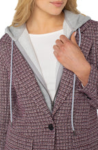 Load image into Gallery viewer, Close-up of model wearing a pattern blazer with detachable hood over a white top.