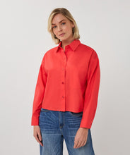 Load image into Gallery viewer, Woman wearing a red shirt and blue jeans on a white background.