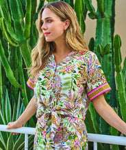 Load image into Gallery viewer, Woman wearing a colorful jungle patterned short sleeve blouse and matching short standing in front of cacti.