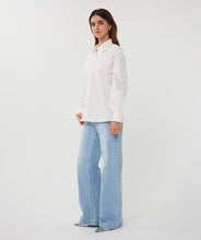 Load image into Gallery viewer, Woman wearing an off-white blouse with lace detailing and blue jeans against a plain background.