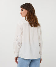 Load image into Gallery viewer, Woman wearing an off-white blouse with lace detailing and blue jeans against a plain background.