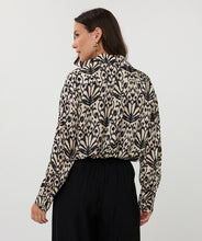 Load image into Gallery viewer, Woman wearing an abstract print top in black and beige and black pants against a white background.