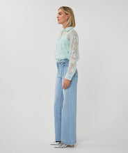 Load image into Gallery viewer, Woman wearing a light mint blouse, jeans and silver heels on a white background.