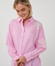Load image into Gallery viewer, Woman wearing a pink striped shirt with floral embroidery on a plain background.