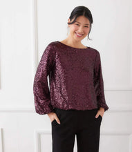 Load image into Gallery viewer, Woman wearing a sparkling purple long sleeve top and black pants against a white background.