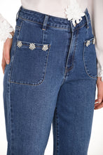 Load image into Gallery viewer, Close up of a woman wearing a white blouse and blue jeans with jewel embellishments against a white background.