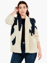 Load image into Gallery viewer, A super comfy classic shaker knit with a few modern touches. The details start at the yarn, where the dominant oatmeal color is accented by flecks of yellow and charcoal to add even more texture and interest. The intarsia knit blocks of black and pink do the rest. A slightly chunkier weight plus the shawl collar and extra length means it's perfect as an outer layer on crisper days. Color-Neutral Multi - oatmeal, (flecks of yellow and charcoal) black, pink. Intarsia knitting. Heavier weight.