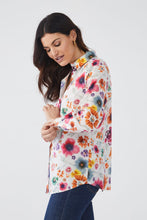 Load image into Gallery viewer, This vibrant top is a must-have for the upcoming seasons of spring and summer. Featuring a bold floral print set against a crisp white background, this long sleeve shirt can be dressed up or down with ease. Simply tie it at the waist and pair with shorts for a casual look or elevate an outfit by pairing with trousers for a standout office ensemble.