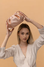 Load image into Gallery viewer, This spacious bag is perfect for carrying all of your essentials when you're on the go! Constructed with luxurious vegan leather, you can remove the chain for a chic, minimalistic clutch look. Effortlessly transition your look from day to night with this stylish bag. Color- Champagne. Drawstring closure. Crystals. Removable chain. Interior slit pocket. Vegan leather. PETA certified.