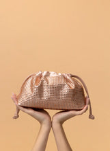 Load image into Gallery viewer, This spacious bag is perfect for carrying all of your essentials when you're on the go! Constructed with luxurious vegan leather, you can remove the chain for a chic, minimalistic clutch look. Effortlessly transition your look from day to night with this stylish bag. Color- Champagne. Drawstring closure. Crystals. Removable chain. Interior slit pocket. Vegan leather. PETA certified.