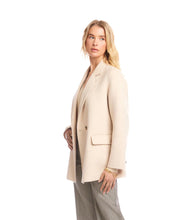 Load image into Gallery viewer, Woman wearing an oatmeal overcoat over an oatmeal v-neck top and striped pants against a white background.
