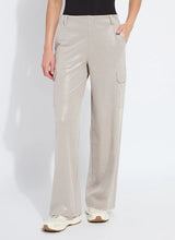 Load image into Gallery viewer, Model wearing soft taupe shiny cargo pants, black top and white sneakers against a white background.