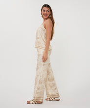 Load image into Gallery viewer, Woman wearing a beige and white safari patterned camisole and matching pant and white sandals against a white background.