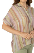Load image into Gallery viewer, Make a statement in this watercolor printed woven top featuring a hi-low hem! Pastel hues of pinks and greens make this top the perfect addition to your wardrobe. Pairs beautifully with denim or dress it up with a trouser! Looks fabulous paired with our Spanish Moss Liverpool LA jacket. Colors- Watercolor Stripe Print - Pinks, greens, lilac, tan. Short sleeve. Inverted placket. Collared. Button front. Hi-low hem.