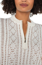 Load image into Gallery viewer, Close-up of a woman wearing a textured cream zip-up sweater with camel stitching throughout.