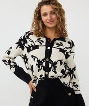 Load image into Gallery viewer, Add a touch of sophistication to your wardrobe with our Short Two-Tone Jacquard Cardigan. This stylish cardigan features a unique two-tone jacquard knit in a floral pattern and includes shiny upscale buttons, creating a chic and elegant look. The round neckline and long sleeves provide a classic silhouette, while the ribbing at the neckline, cuffs, and hem adds a polished finish. Perfect for layering over a simple dress or pairing with jeans for a trendy, effortless style.