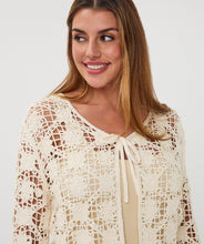 Load image into Gallery viewer, Close-up of woman wearing a natural color crochet cardigan against a white background.
